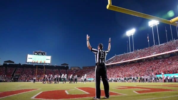 a football player standing on a field with his arms in the air
